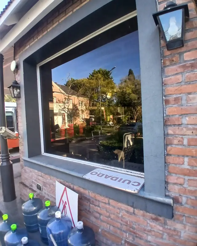 Vidriera de un local con frente de ladrillo durante la instalación de lámina