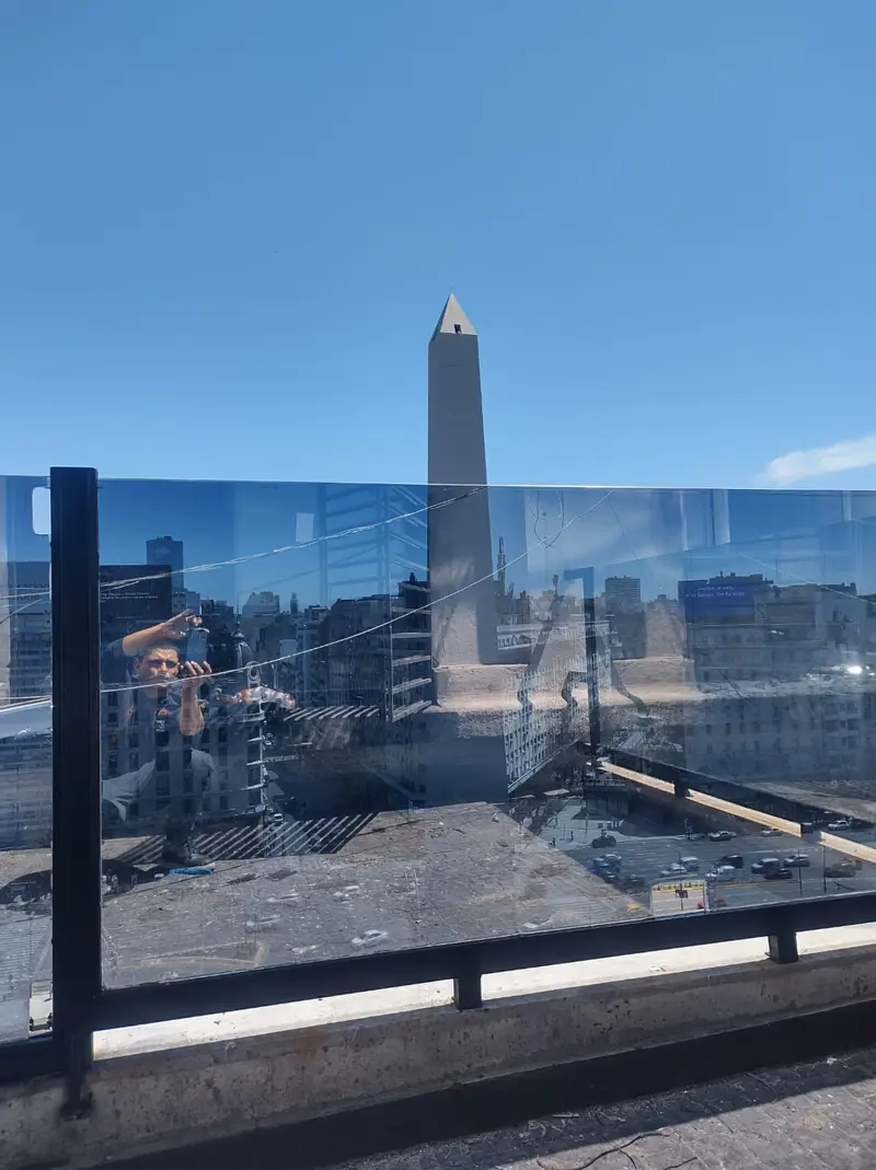 Baranda de vidrio con lámina en una terraza frente al Obelisco